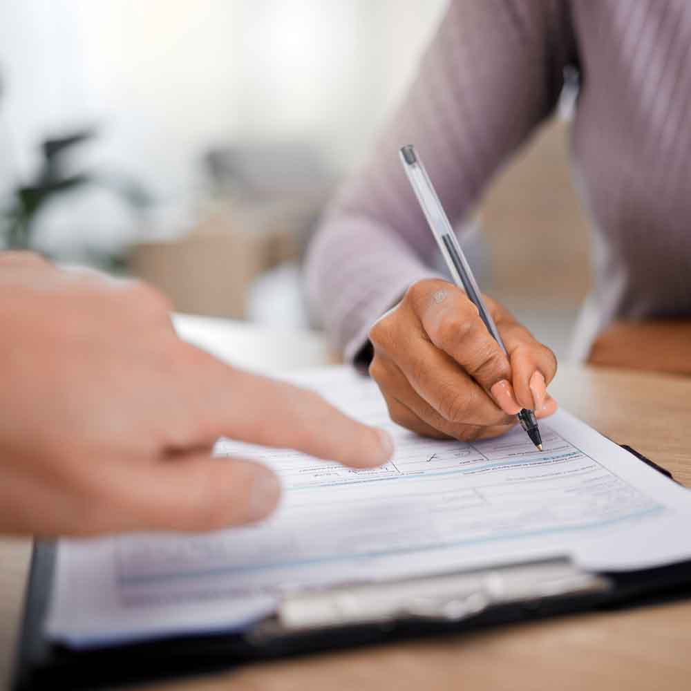 An attorney at Dunham Law LLC helps a client fill out their estate planning legal paperwork.