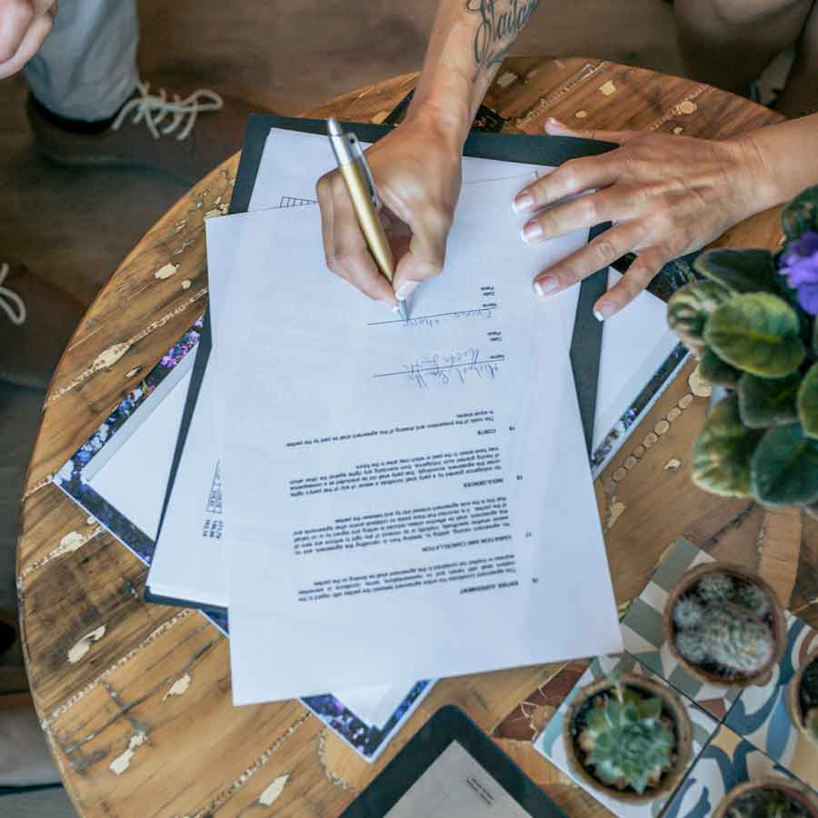 New homeowner signs legal paperwork with an attorney from Dunham Law LLC to buy a new home.